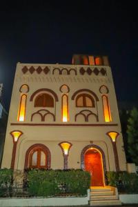 卢克索Shahhat House的一座白色的大建筑,上面有橙色的灯光
