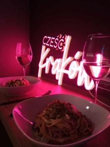 克拉科夫Apartamenty Cześć Kraków的一张桌子,上面放着一盘意大利面和一杯葡萄酒