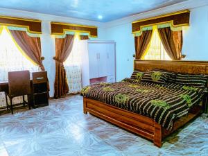 阿布贾Select Elegant 3 Rooms 3 sized king-bed @ Abuja FCT的卧室配有一张床、一张书桌和窗户。