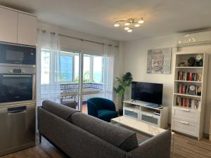 贝纳尔马德纳Luxury beachfront apartment in Benalmadena Costa的带沙发和电视的客厅