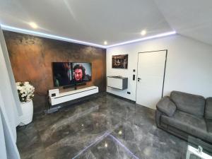 帕德博恩Los Angeles Apartment的客厅配有沙发和墙上的电视