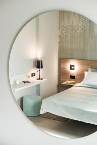 泰尔拉诺Agriturismo Insolito的一间卧室配有床和圆镜子