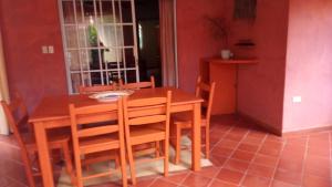 拉斯特拉纳斯Hotel - Residencial Madrugada的一间带木桌和椅子的用餐室