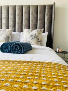 约翰内斯堡Maboneng Modern Style的一张带蓝色毯子和枕头的床