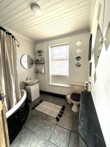 利兹Leeds Cosy House的带浴缸、卫生间和盥洗盆的浴室