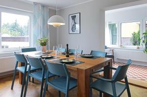 德累斯顿Haus Welzel的一间带木桌和蓝色椅子的用餐室