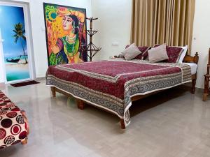瓦尔卡拉Aryavilla Heritage的卧室配有一张大床,墙上挂有绘画作品