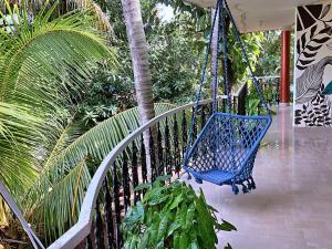 瓦尔卡拉Aryavilla Heritage的棕榈树门廊上的蓝色秋千
