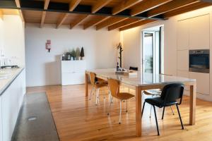 卡马拉-德洛布什Casa Mar Adentro的厨房以及带木桌和椅子的用餐室。