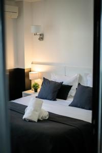 戛纳Hôtel Gallia Cannes的一间卧室配有一张带蓝白色枕头的大床