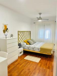 赫塔费Apartamento ABRIL en el Centro de Getafe的一间卧室配有带梳妆台和窗户的床。