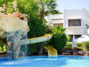 沙姆沙伊赫Apartments for rent in Delta Sharm Resort的游泳池中的水滑梯,游泳池设有喷泉