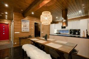 普哈圣山Charming log house - Lumous B - Pyhätunturi - Finland的一间带桌子的用餐室和一间厨房