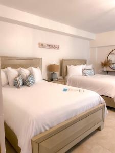林康Tres Palmas by La Cambija的一间卧室配有两张带白色床单的床