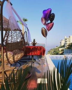 多布拉沃达Apart Lux Beciragic的一个带桌子和气球的庭院,毗邻一个游泳池