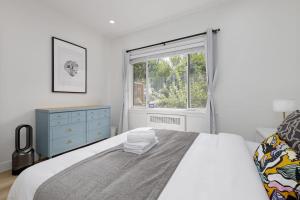 温哥华Spacious Fully Furnished 2-BR Suite的白色的卧室设有床和窗户