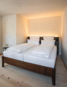 巴特特尔茨Gasthof Zantl的一间卧室配有带白色床单和枕头的床。