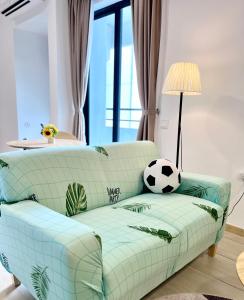 Kampong Pantai DusunNetflix-Seaview-SunsetView-PuteriBeach-Mutiara Beach Resort Melaka的客厅里一张沙发上放足球球