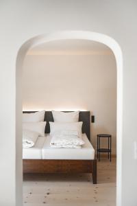 巴特特尔茨Gasthof Zantl的一张带白色床单和枕头的床