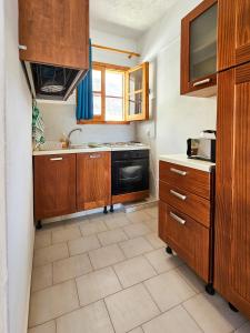 佩基罗德George Seaside Serviced Studios & Apartments的厨房配有木制橱柜和炉灶烤箱。
