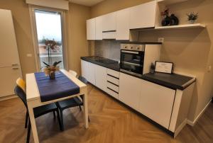 雷焦卡拉布里亚T&L-Home的厨房配有白色橱柜、桌子和用餐室。