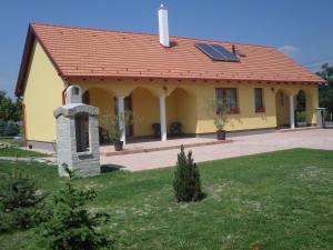 RajkaKiserdő Vendégház的一座黄色的小房子,设有太阳能屋顶