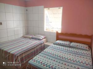 卡诺格布拉达Suítes D'Belinha的带窗户的客房内设有两张单人床。