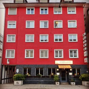 斯图加特Hotel-Restaurant Köhler的红色的建筑,设有白色的窗户