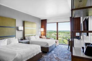 普莱瑟维尔Red Hawk Resort & Casino的酒店客房设有两张床和窗户。