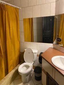 阿拉胡埃拉Alajuela Backpackers Airport Hostel的浴室设有卫生间和黄色的淋浴帘