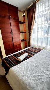 奥塔瓦洛tourist house suites 2的一间卧室配有一张床、一个梳妆台和一扇窗户。