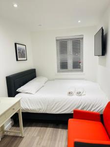 伦敦Riverside En suite Double Room E14的一间卧室配有一张床和一张红色椅子