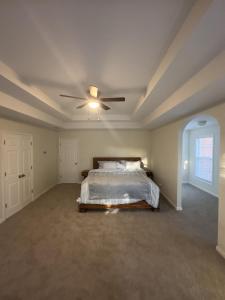 肯尼索Capital Rental的一间卧室配有一张床和吊扇