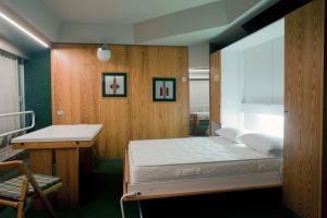马里尔伊瓦Ale1206 Marilleva 1400的一间卧室配有一张床、一张书桌和一个窗户。