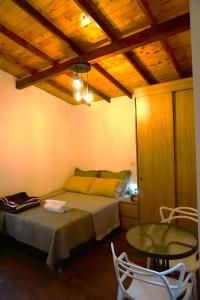 圣埃伦娜ENCANTO Minicasitas en medio de la naturaleza的卧室配有一张床和一张桌子及椅子