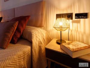 阿卡斯Villa Eliá的一张带台灯和书的桌子的床