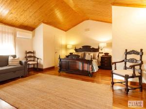 阿卡斯Villa Eliá的一间卧室配有一张床、一张沙发和一把椅子
