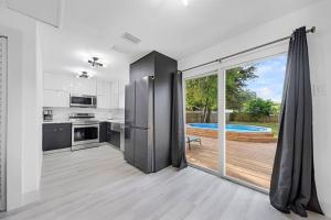 劳德代尔堡Home In Fort Lauderdale 3 Bedrooms & private pool!的厨房设有滑动玻璃门,可通往游泳池