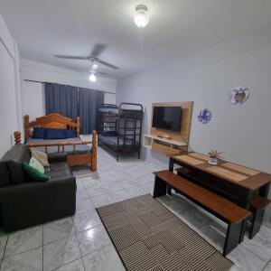 乌巴图巴Kitnet Ubatuba的带沙发、电视和床的客厅