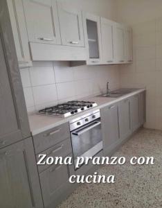 瓦斯托Lo Studio del Pittore的厨房配有白色橱柜和炉灶烤箱。