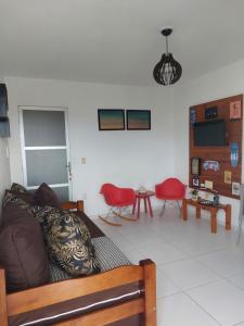 皮帕Zapipou - Apartamento aconchegante para você aproveitar o melhor de Pipa的带沙发和红色椅子的客厅
