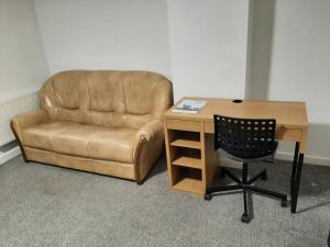 米德尔斯伯勒Exclusive Self-contained flat in Middlesbrough的一张棕色皮椅,旁边是桌子和椅子,西德西德