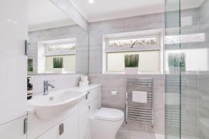 桑赫斯特Luxury 5 BDR 2 BA House with Parking in Sandhurst By 360Stays的白色的浴室设有卫生间和水槽。