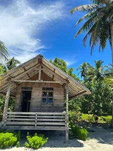 Pulau PalambakbesarPalambak Paradise Resort Pulau Banyak的海滩上的小房子,有棕榈树