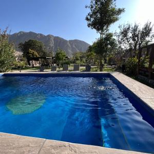 卢那欢纳Refugio de Santiago Ecolodge的蓝色的海水和山脉背景的游泳池