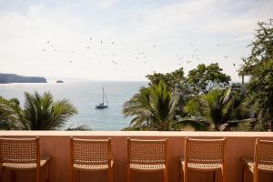 恰卡拉Casa Liquen的阳台配有椅子和水中的帆船