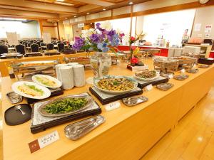 东伊豆町热川伊东园酒店的餐桌上的自助餐,包括盘子