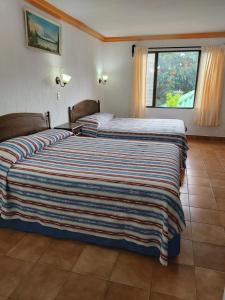 帕纳哈切尔佩拉玛雅酒店的一间卧室设有两张床和大窗户