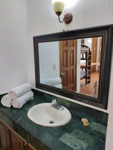 帕纳哈切尔佩拉玛雅酒店的浴室设有水槽和镜子,位于柜台上