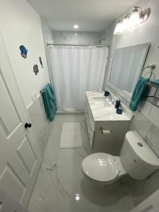 沃思湖Mango Tree House的白色的浴室设有卫生间和水槽。